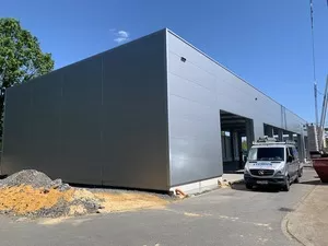 Graue Stahlhalle von außen während des Aufbaus